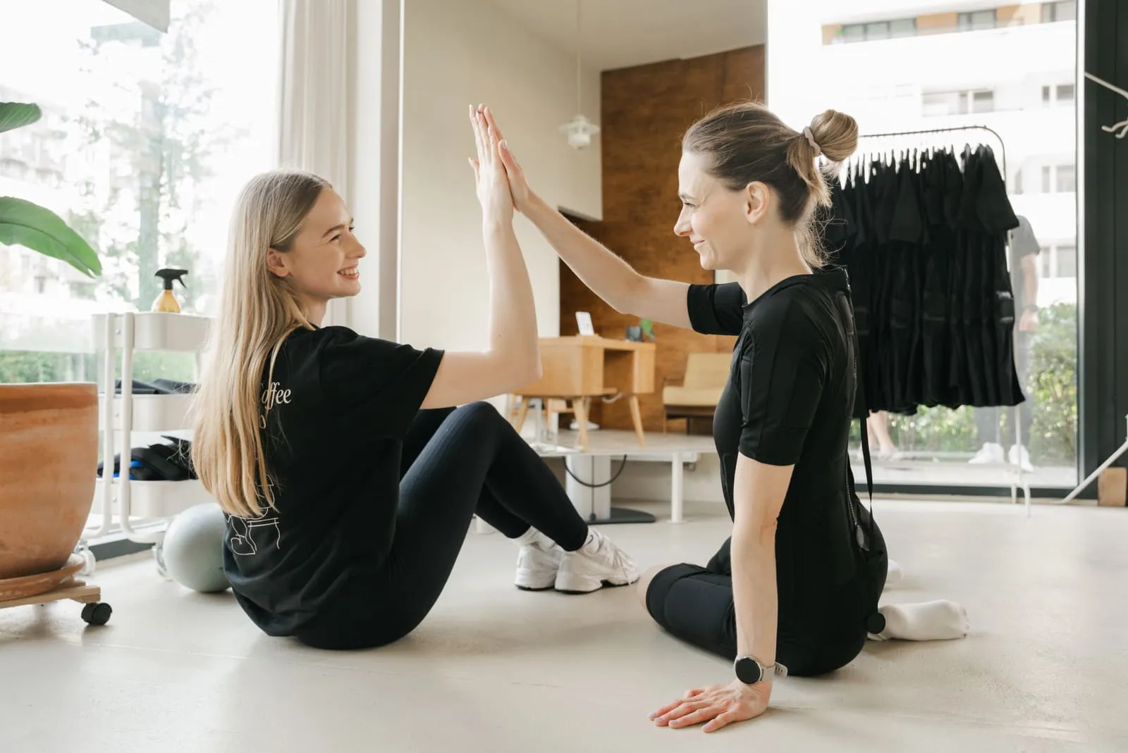 A client and coach high-five after finishing a session on the mat