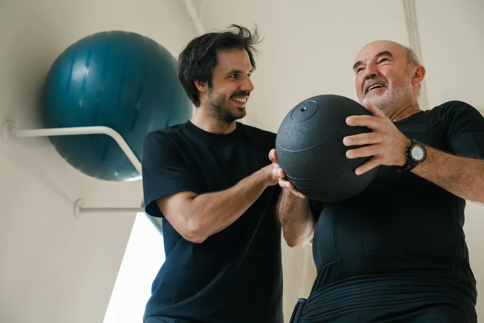 A coach and client passing a medicine ball between them during a session