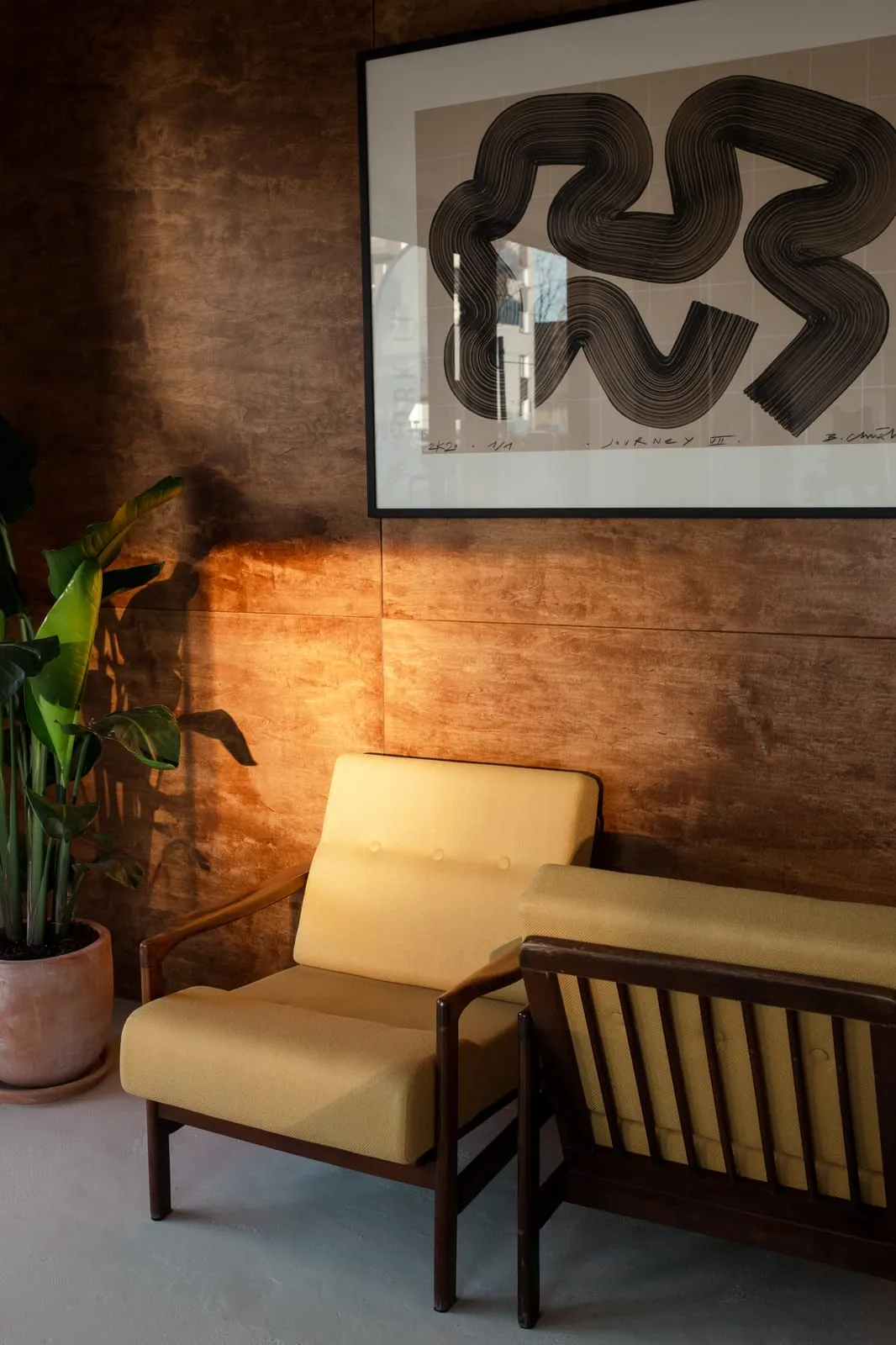 Yellow armchairs and artwork on the wooden wall in the lounge area